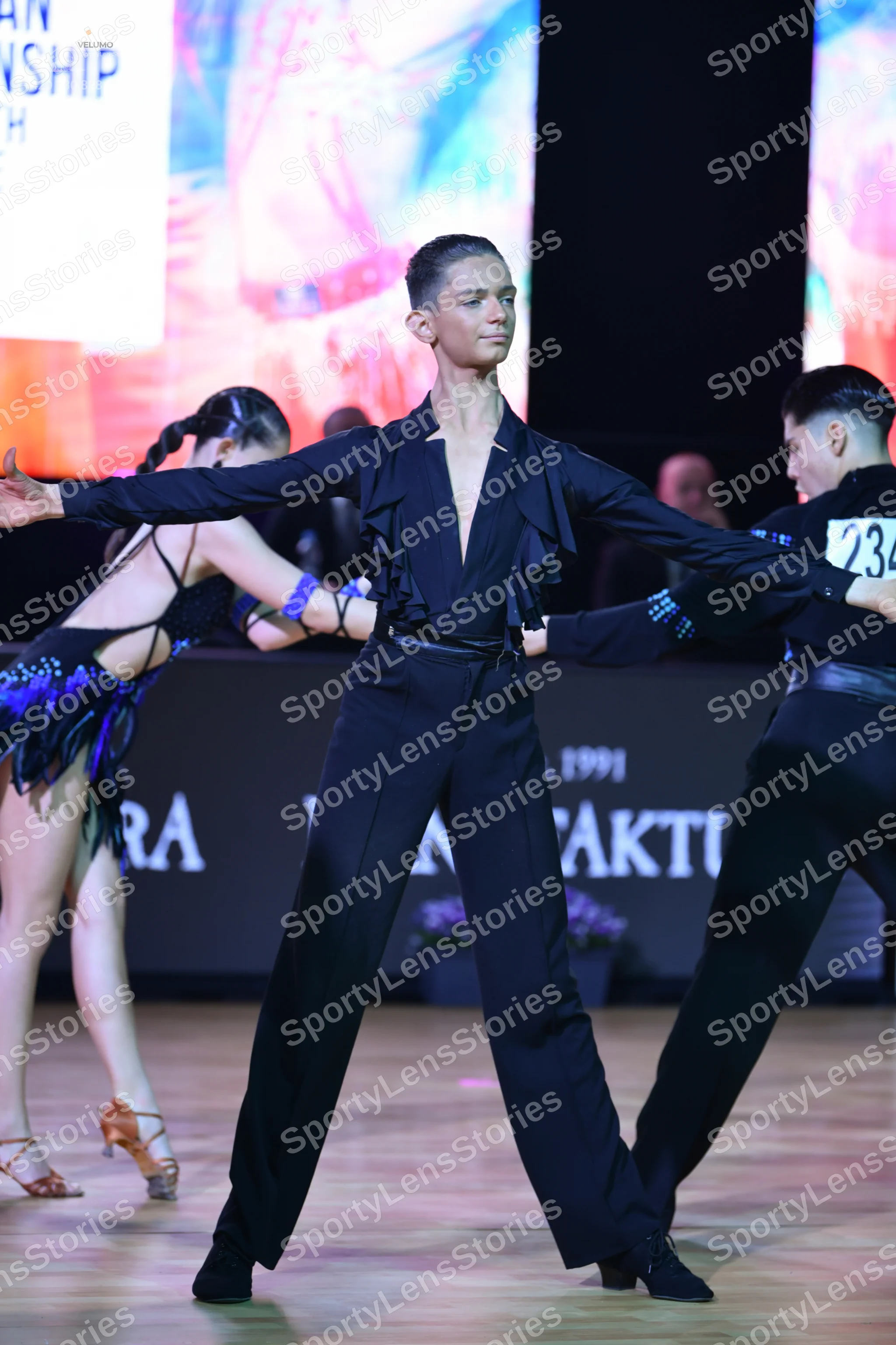 Dancesport competitor: Female dancer: black latin dress with blue fringe