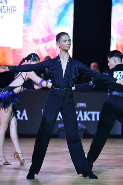 Dancesport competitor: Female dancer: black latin dress with blue fringe