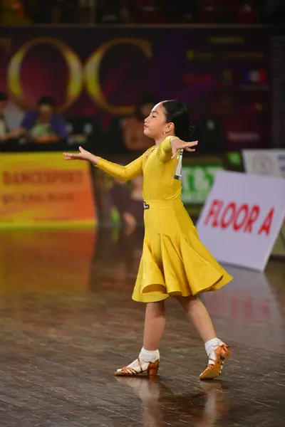 Dancesport competitor: Female dancer: yellow long-sleeved dress with a flared skirt