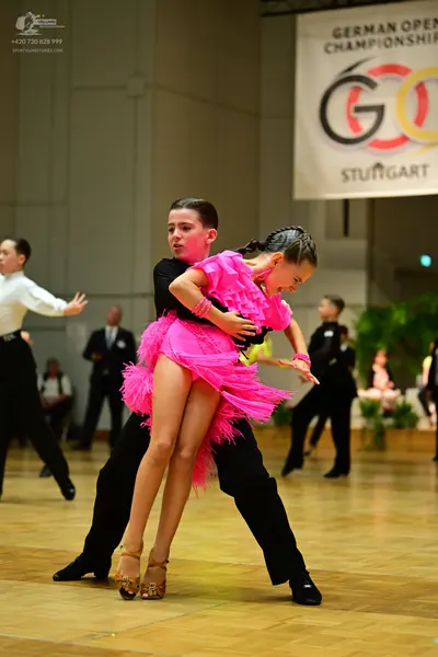 Dancesport competitor: Female dancer: bright pink Latin dress with heavy fringe
