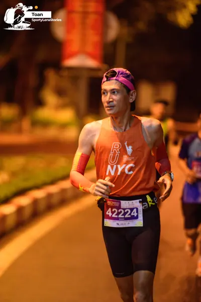 Marathon runner #42224: Runner 1: orange tank top, black compression shorts, pink cap, yellow arm sleeve