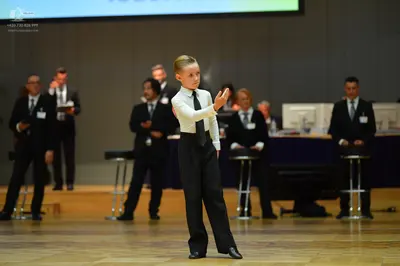 Dancesport competitor: Child dancer: white long-sleeved shirt, black necktie, and black trousers