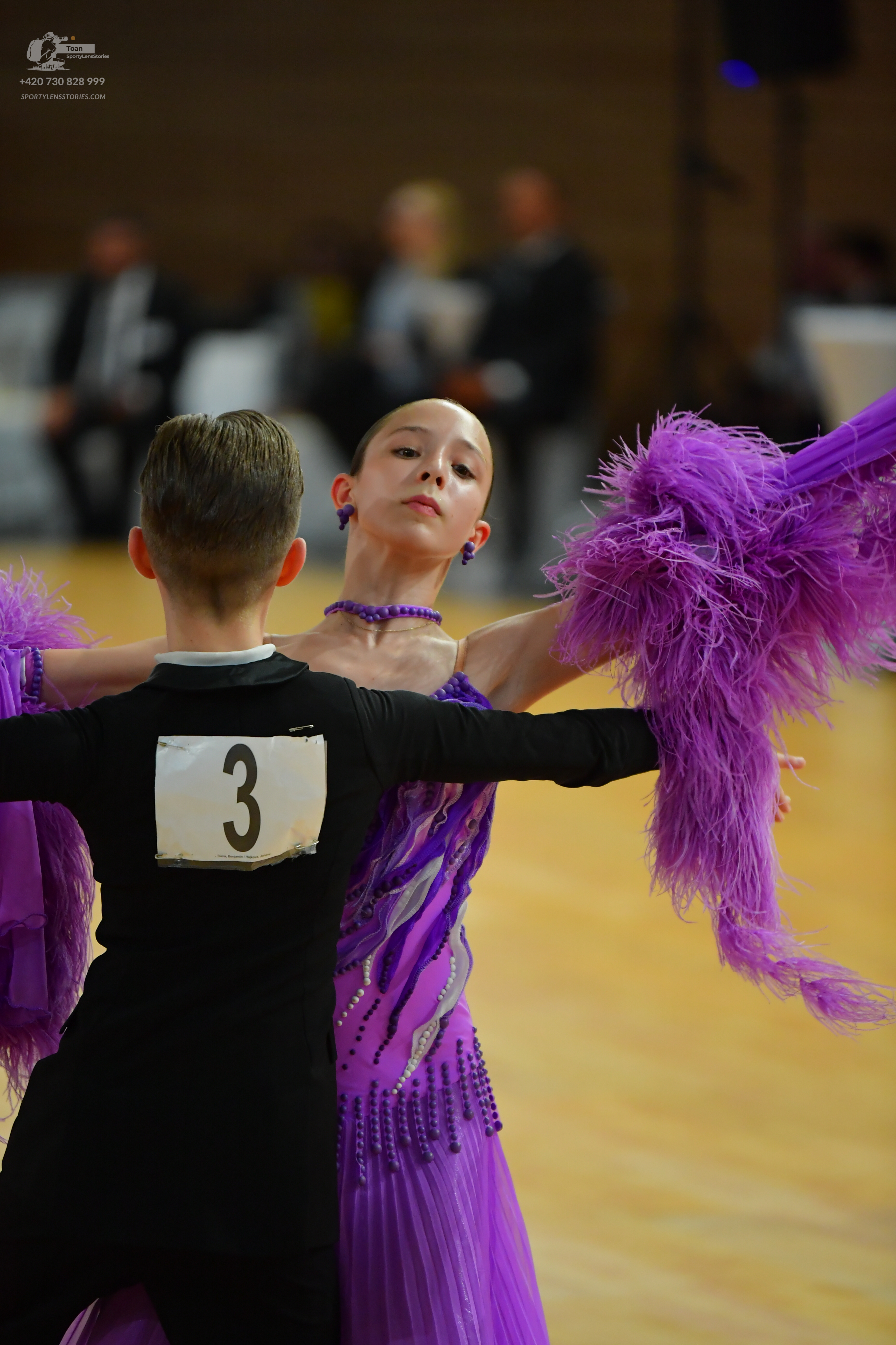 Dancesport competitor #3: Male** 
*   **Color:** Dark purple/black
*   **Fabric:** Likely a satin or crepe