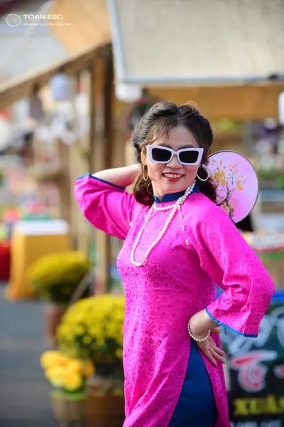 Dancesport competitor: Female dancer: pink long-sleeved tunic with blue trim and subtle floral pattern,