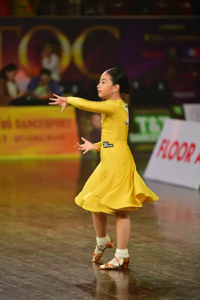 Dancesport competitor: Female dancer: yellow long-sleeved dress with a flared skirt