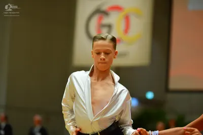 Dancesport competitor: Male dancer: white satin long-sleeve shirt, unbuttoned, with black trousers