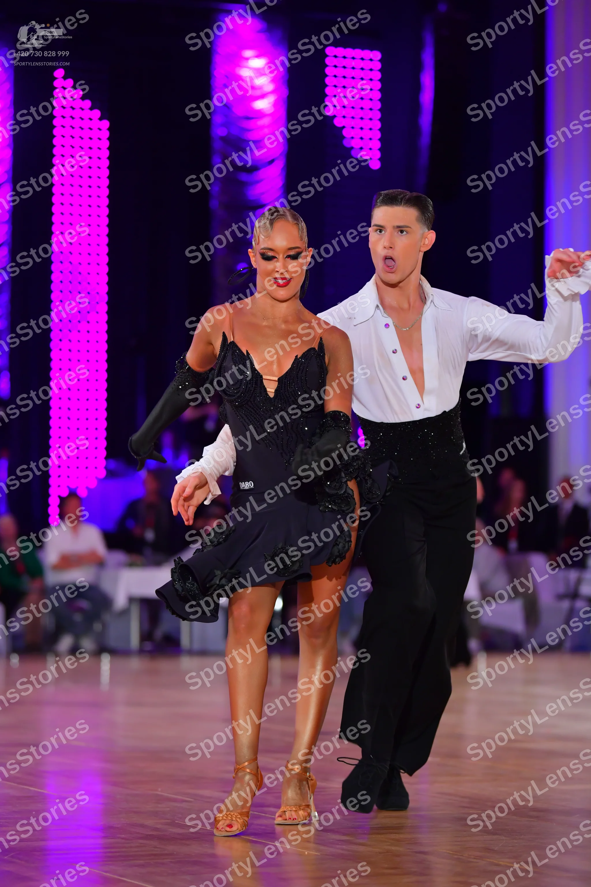 Dancesport competitor: Female dancer: black Latin dance dress with sequins and textured floral-like emb