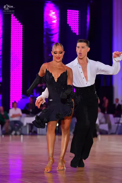 Dancesport competitor: Female dancer: black Latin dance dress with sequins and textured floral-like emb