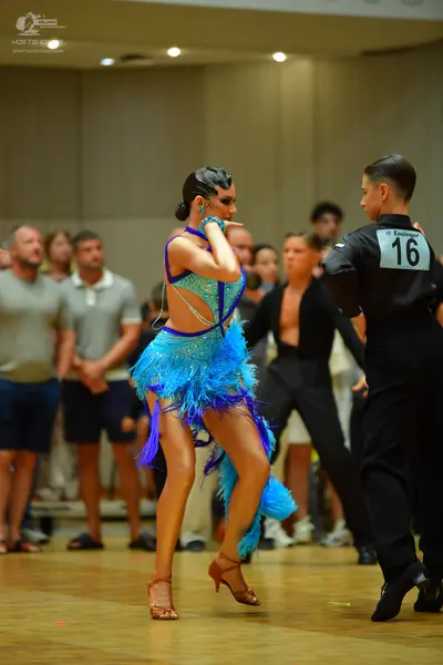 Dancesport competitor: Female dancer: bright blue Latin dance dress with fringe and sequins