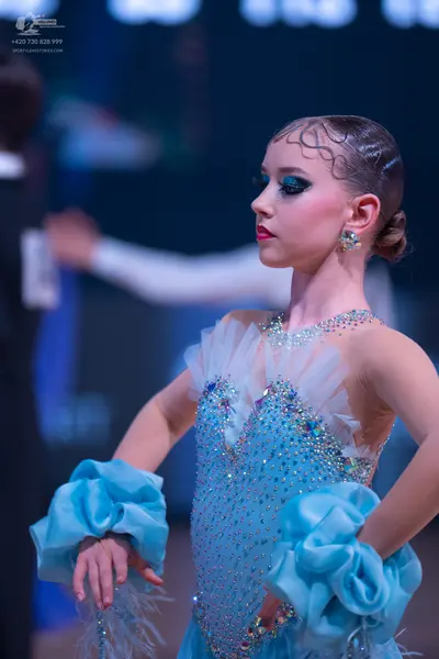 Dancesport competitor: Female dancer: light blue ballroom dress heavily embellished with crystals and s