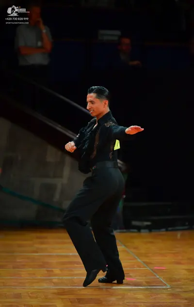 Dancesport competitor: Male dancer: black shirt with sequins and a neon yellow panel, black trousers, a