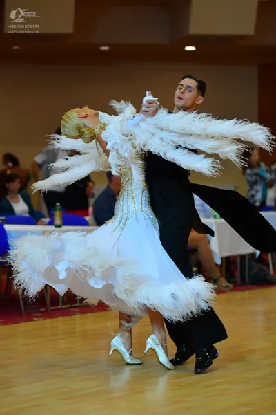 Dancesport competitor: Female dancer: white ballgown with large white feathers on the bodice, sleeves, 