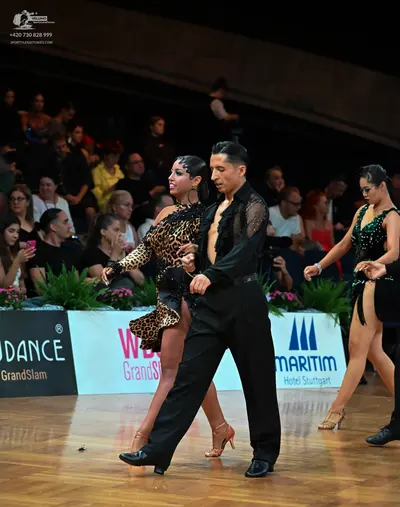Dancesport competitor: Female dancer (left): leopard print latin dress with long sleeves and skin-toned
