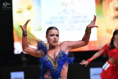 Dancesport competitor: Female dancer: blue latin dress with sequins and feathers