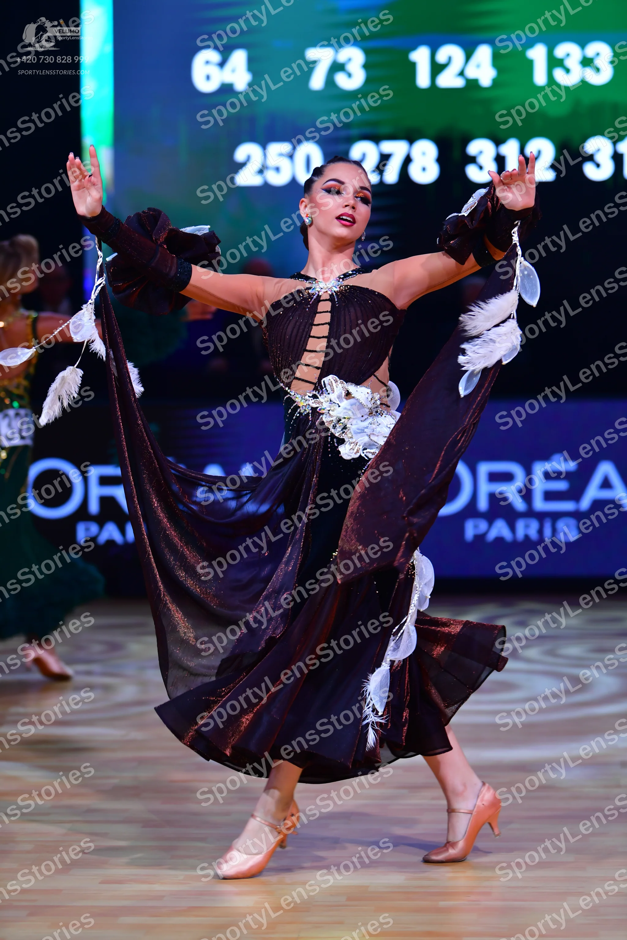 Dancesport competitor: Main dancer: dark brown or black ballroom dress with metallic shimmer, featuring