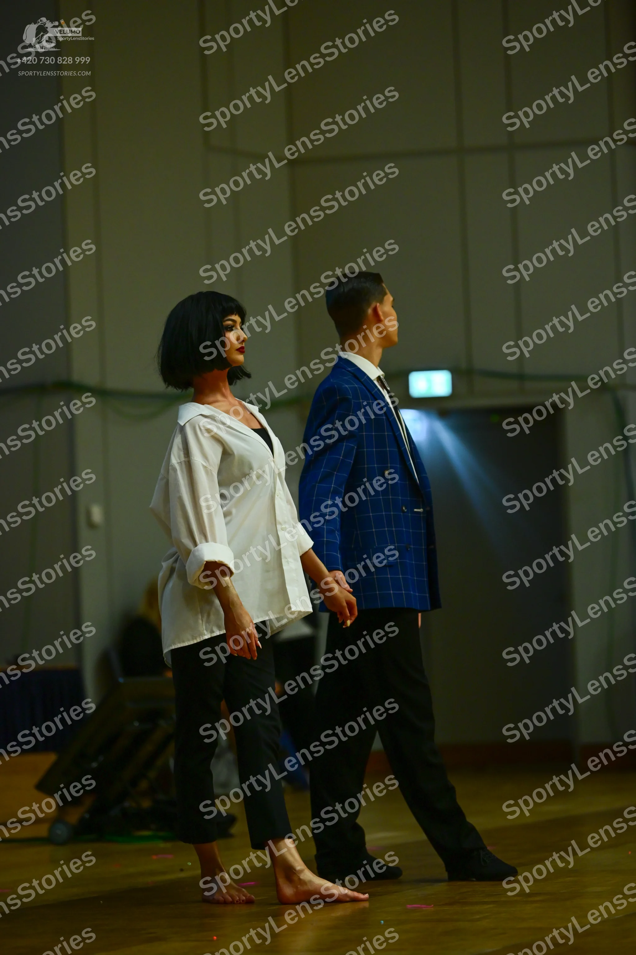 Dancesport competitor: Female dancer: white long-sleeved button-down shirt and black trousers