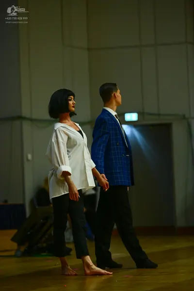 Dancesport competitor: Female dancer: white long-sleeved button-down shirt and black trousers