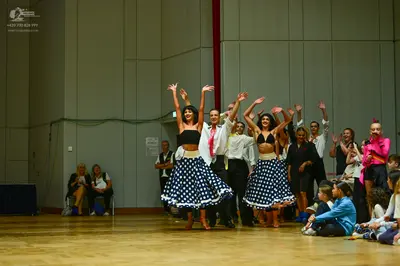 Dancesport competitor: Female dancers: black sleeveless crop tops and full, flared skirts with white po