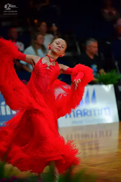 Dancesport competitor: Female dancer: red latin dress with feathery/fringed texture and red arm sleeves