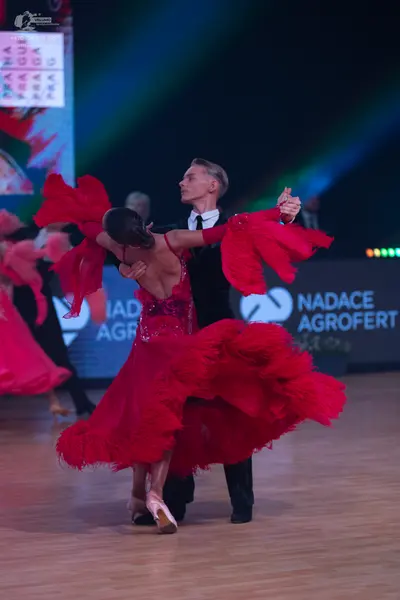 Dancesport competitor: Female dancer: red Latin dance dress with a sequined bodice and a voluminous, ru