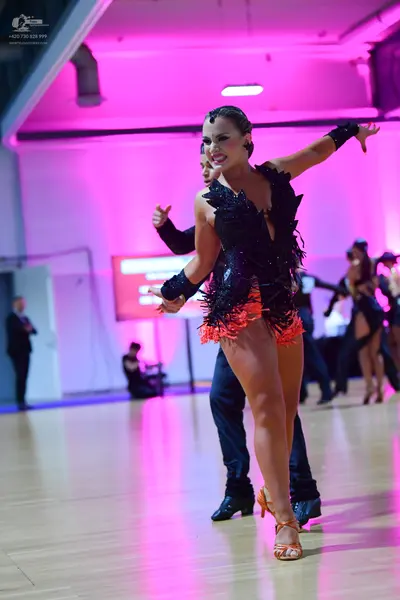 Dancesport competitor: Female dancer: black Latin dress with a sequin-embellished bodice and orange fri