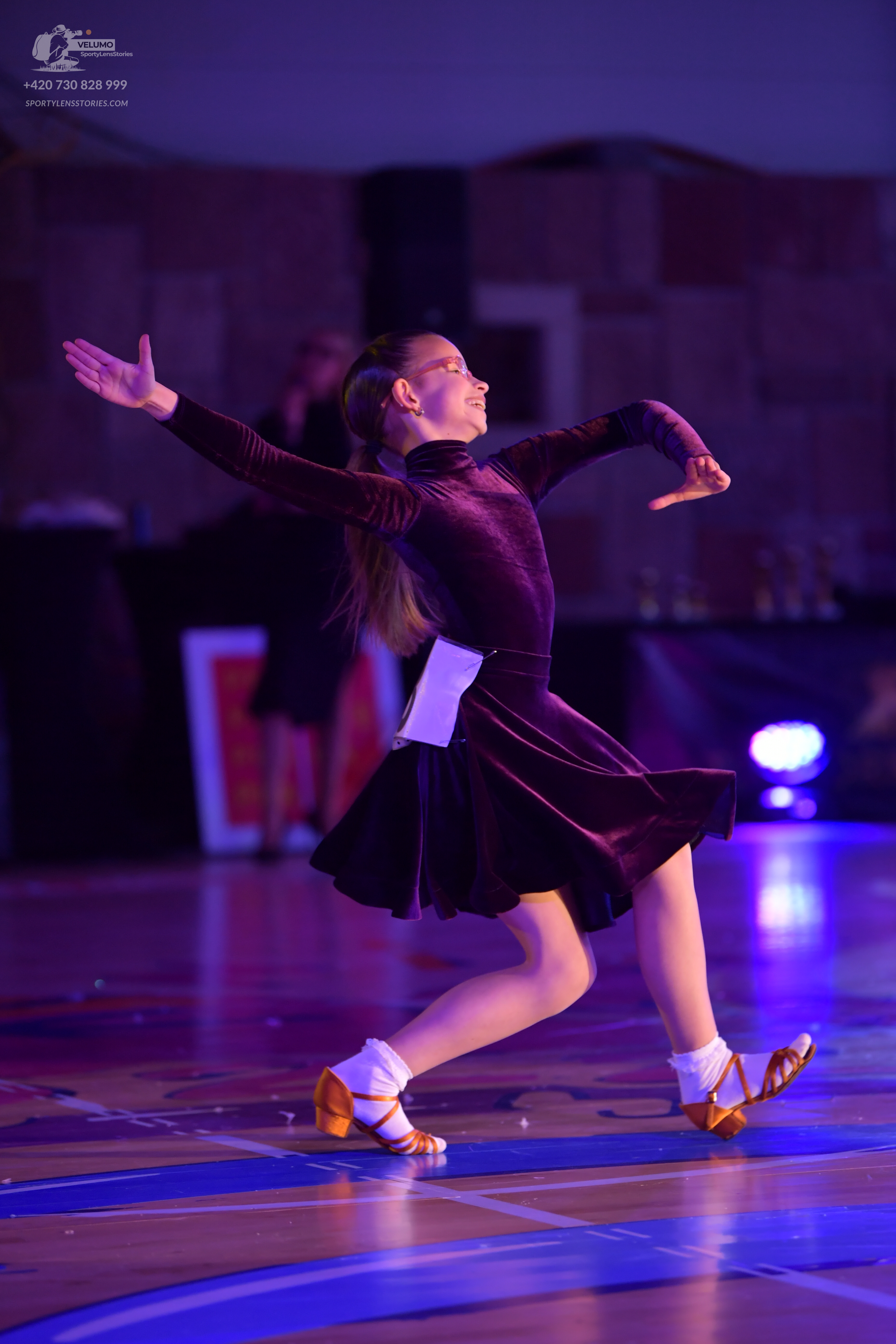 Dancesport competitor: Female dancer: dark burgundy velvet long-sleeved ballroom dress with a flared sk