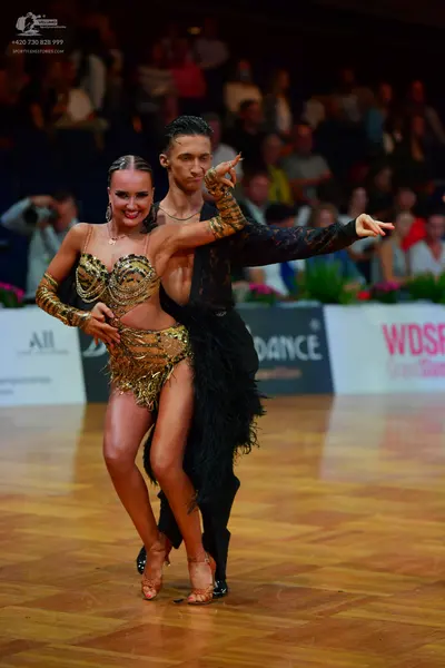 Dancesport competitor: Male dancer: black long-sleeved Latin costume with fringe