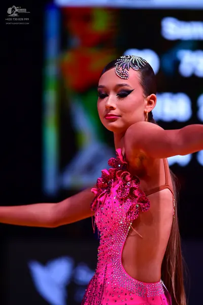 Dancesport competitor: Female dancer: bright pink Latin dress, heavily embellished with rhinestones, fe