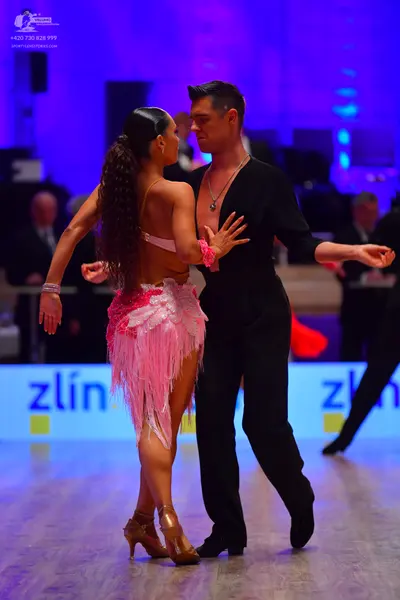 Dancesport competitor: Male dancer: black long-sleeved top with a V-neck and black trousers