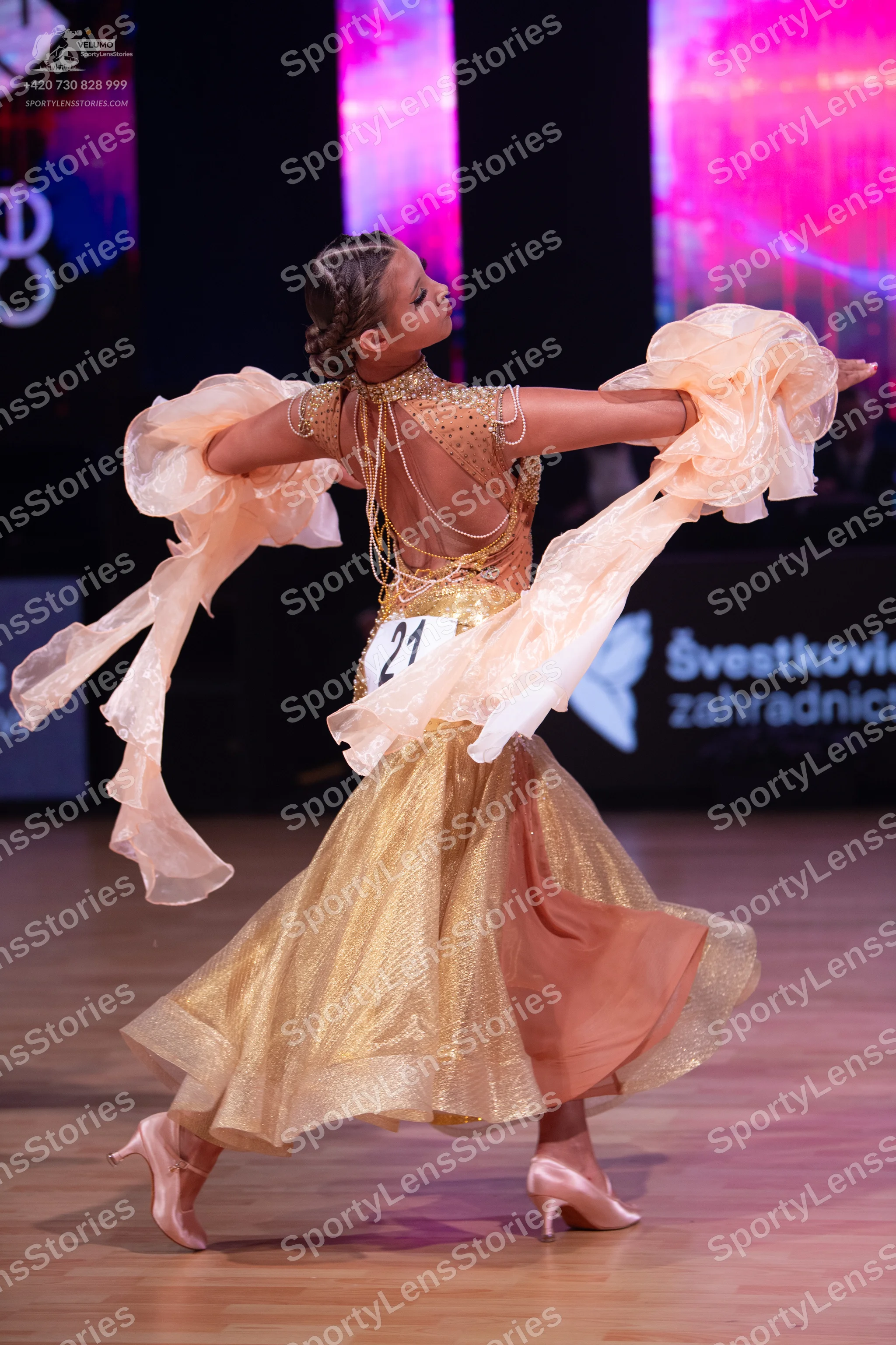 Dancesport competitor: Female dancer: light gold/champagne ballroom gown with a sheer/nude bodice featu