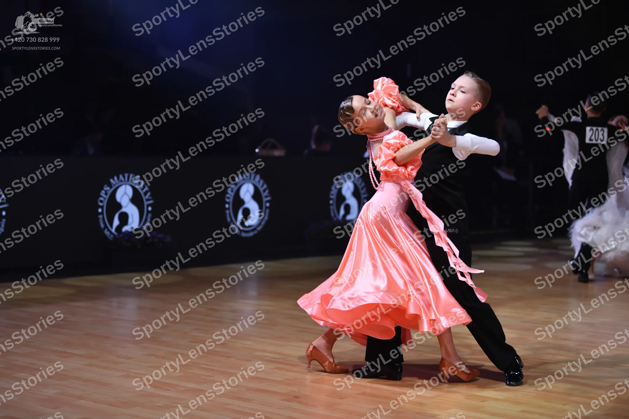 Dancesport competitor: Female dancer: peach satin dress with ruffled sleeves and a flowing skirt