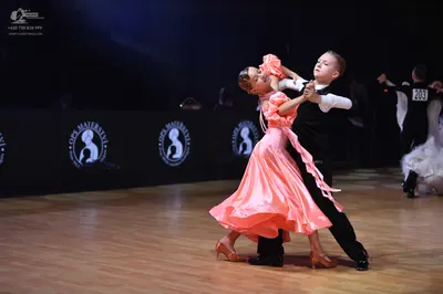 Dancesport competitor: Female dancer: peach satin dress with ruffled sleeves and a flowing skirt