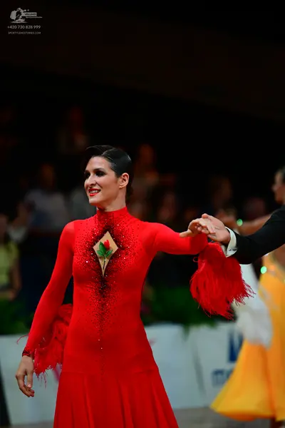 Dancesport competitor: Female dancer: red long-sleeved latin dress with a diamond-shaped cutout featuri