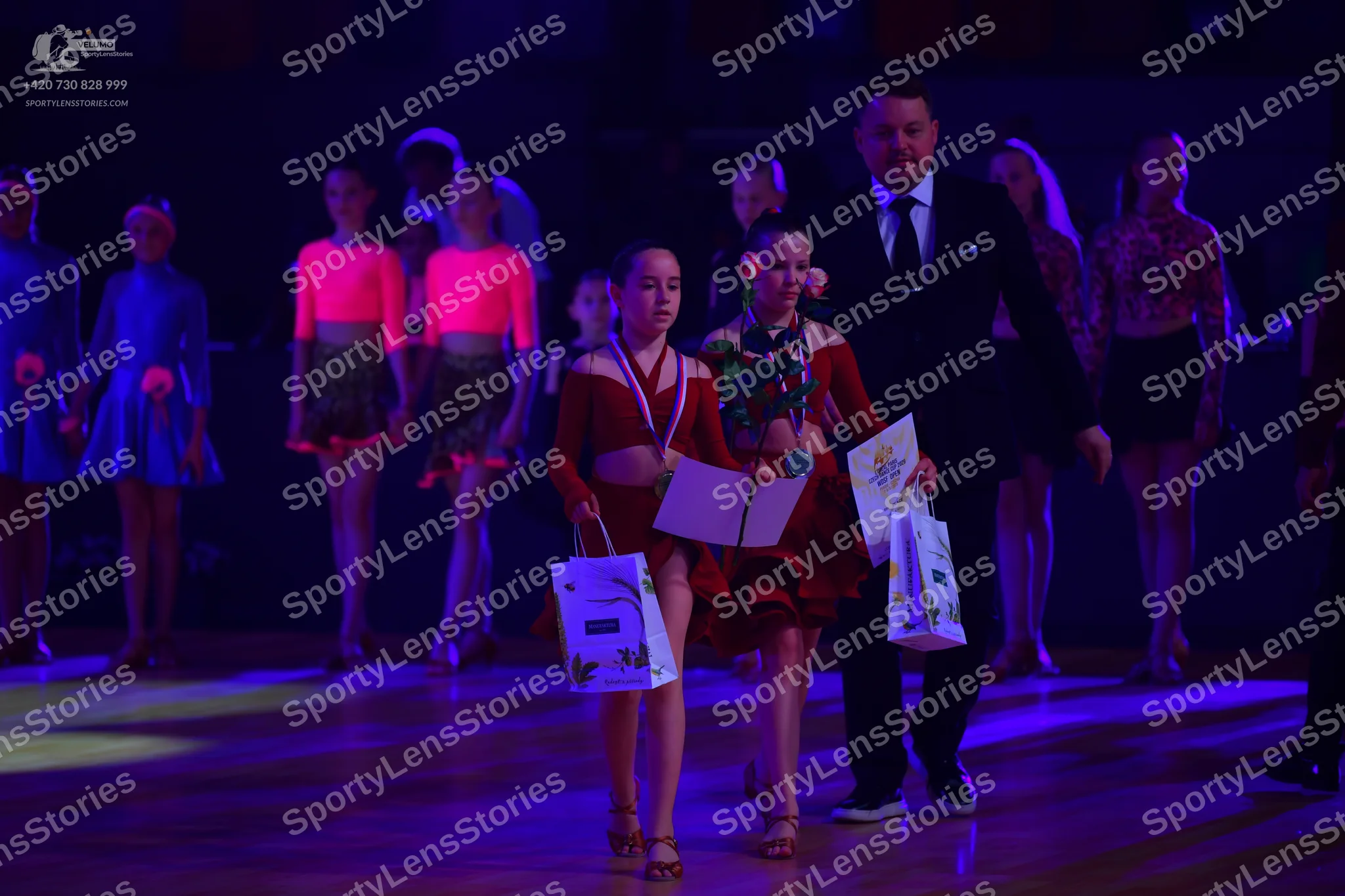 Dancesport competitor: Dancers on the left: blue satin-like dresses
