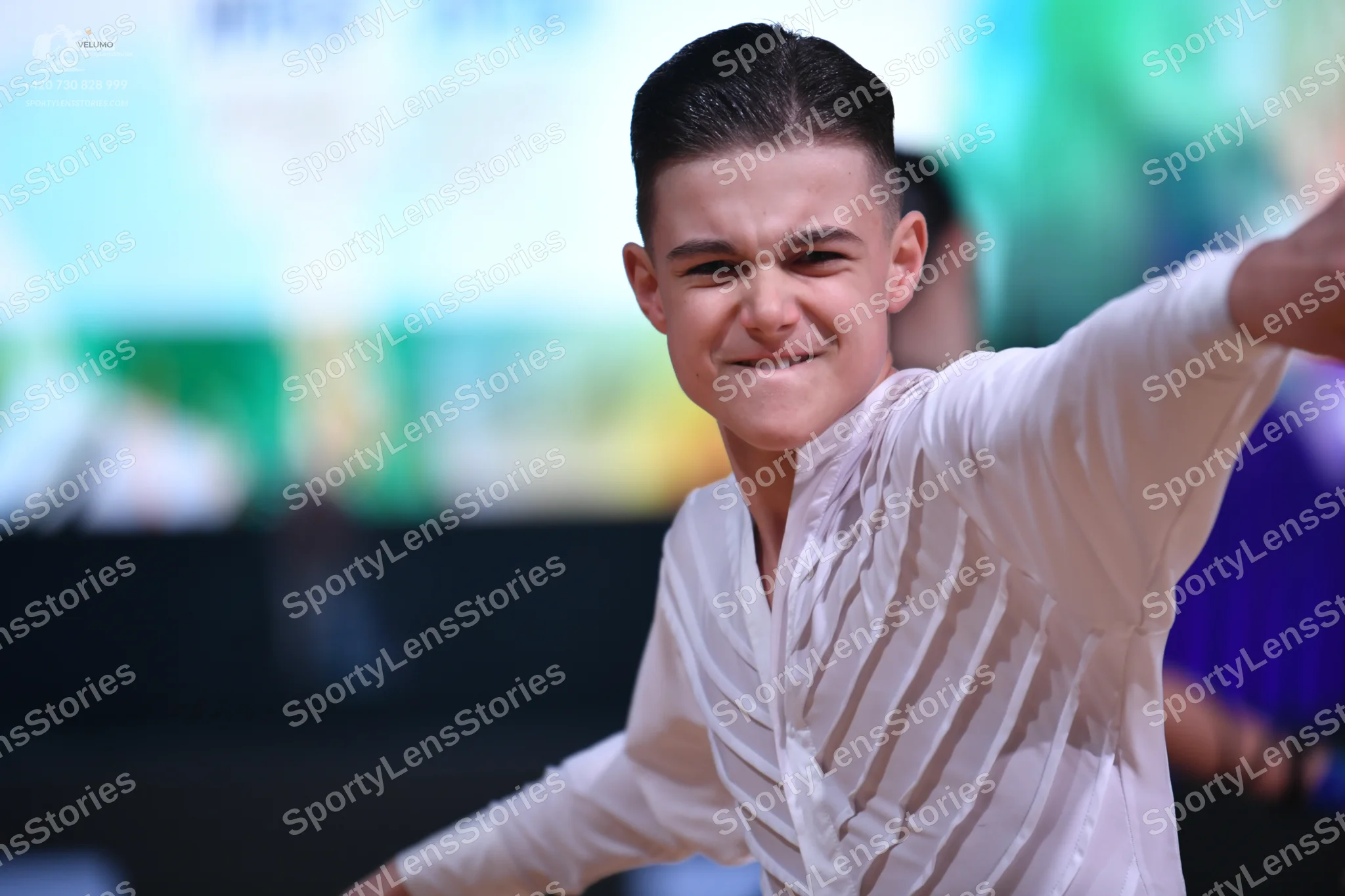 Dancesport competitor: Male dancer in foreground: white long-sleeved latin dance shirt with vertical te