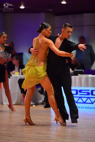 Dancesport competitor: Female dancer: yellow sequined latin dress with a backless design