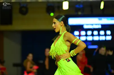 Dancesport competitor: Female dancer: lime green Latin dress with long fringe and matching armbands