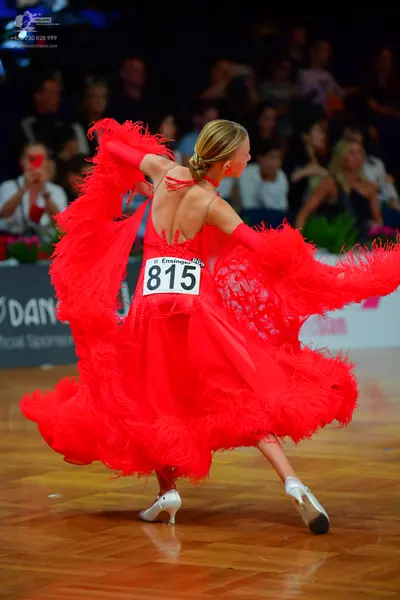 Dancesport competitor #815: Female dancer: red latin dress with large red feather-like fringe, red gloves, a