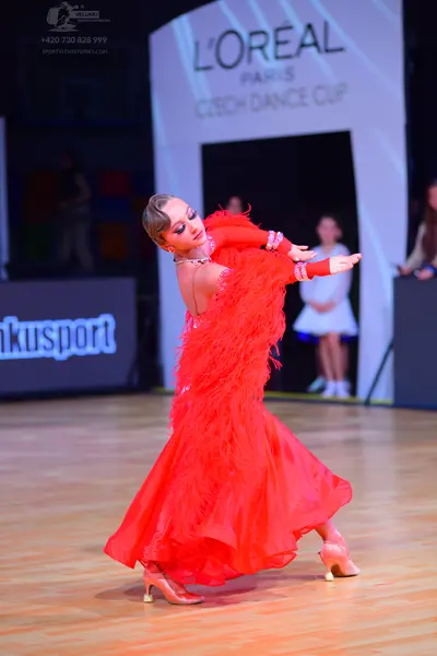 Dancesport competitor: Female dancer: red Latin dance dress with long fringe and nude dance heels
