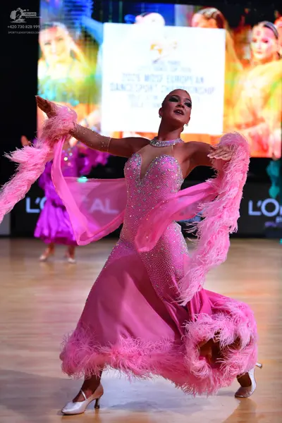 Dancesport competitor: Female dancer (foreground): pink ballgown with a crystal-embellished bodice and 