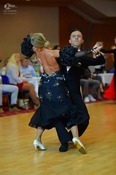 Dancesport competitor: Female dancer: black ballroom dress with large, voluminous black ruffles or fabr