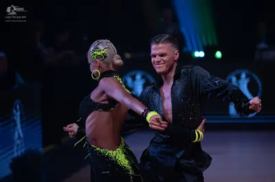 Dancesport competitor: Female dancer: black latin costume with neon yellow/lime green sequin and fringe