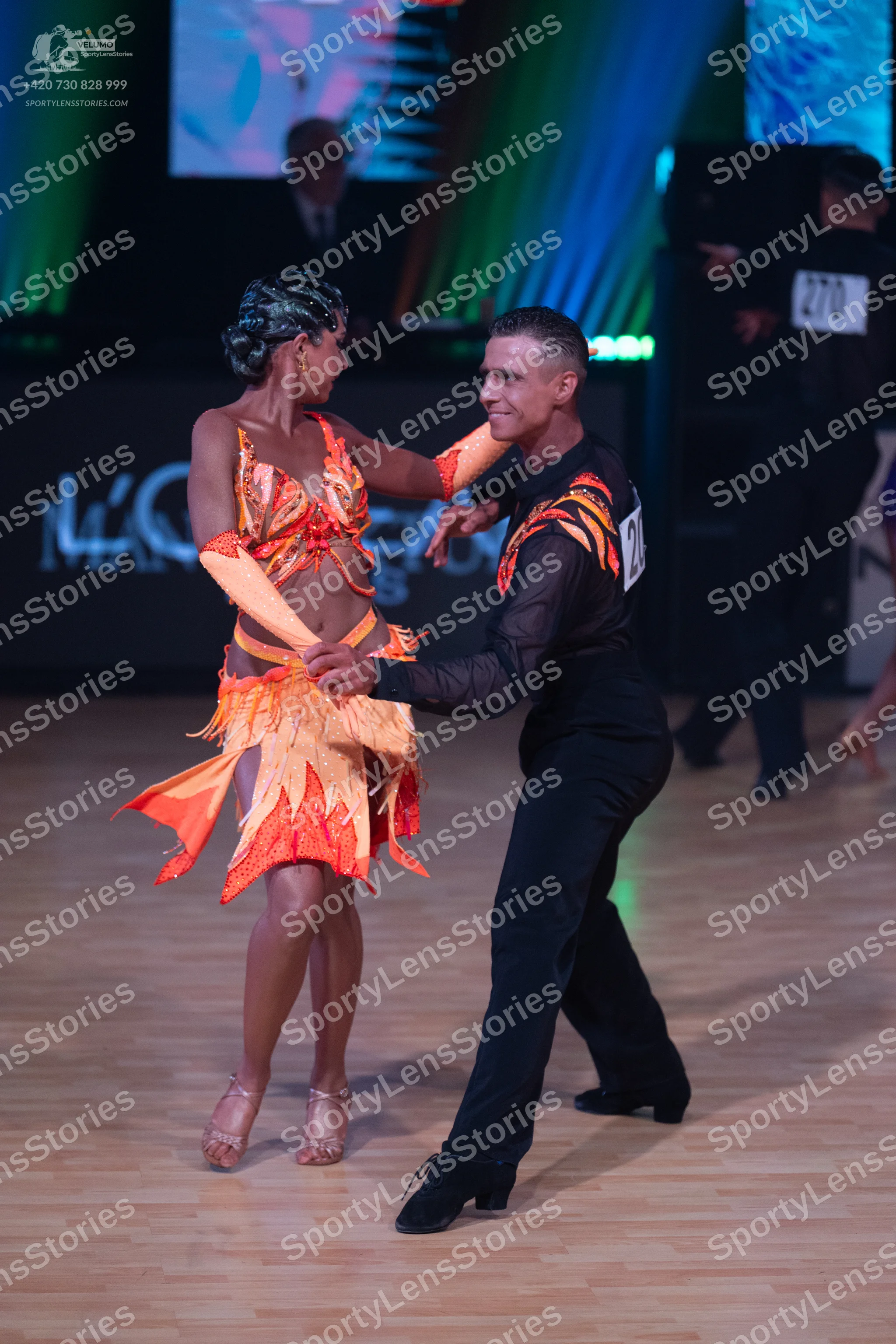 Dancesport competitor: Male dancer: black long-sleeved Latin dance shirt with orange flame-like pattern