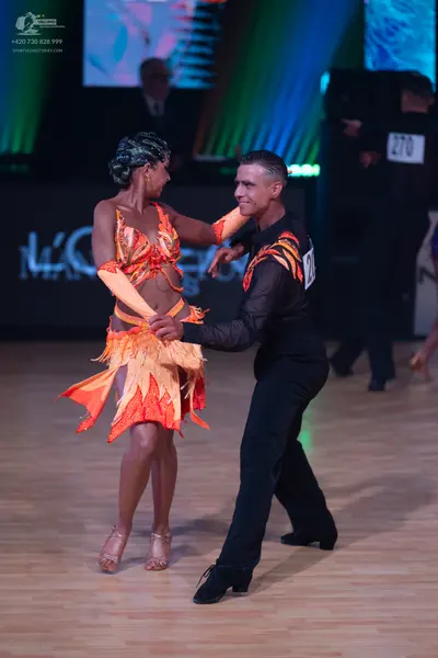 Dancesport competitor: Male dancer: black long-sleeved Latin dance shirt with orange flame-like pattern
