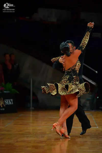 Dancesport competitor: Female dancer: leopard print latin dress with long sleeves, black sequin embelli