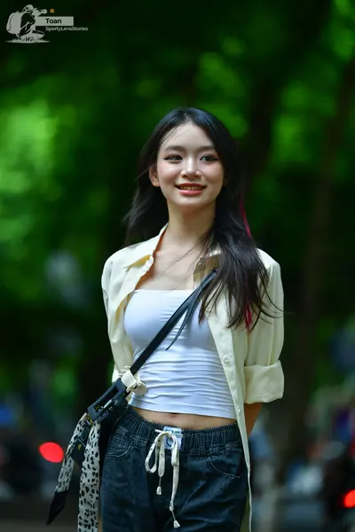 Dancesport competitor: Female dancer: white tank top, light cream-colored open button-down shirt, and d