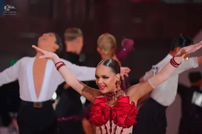 Dancesport competitor: Male dancer: white long-sleeved shirt with a deep V-neck and black trousers