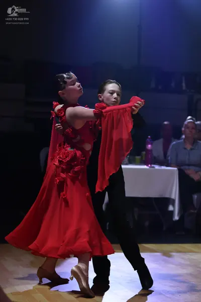 Dancesport competitor: Female dancer: red Latin dress with floral embellishments