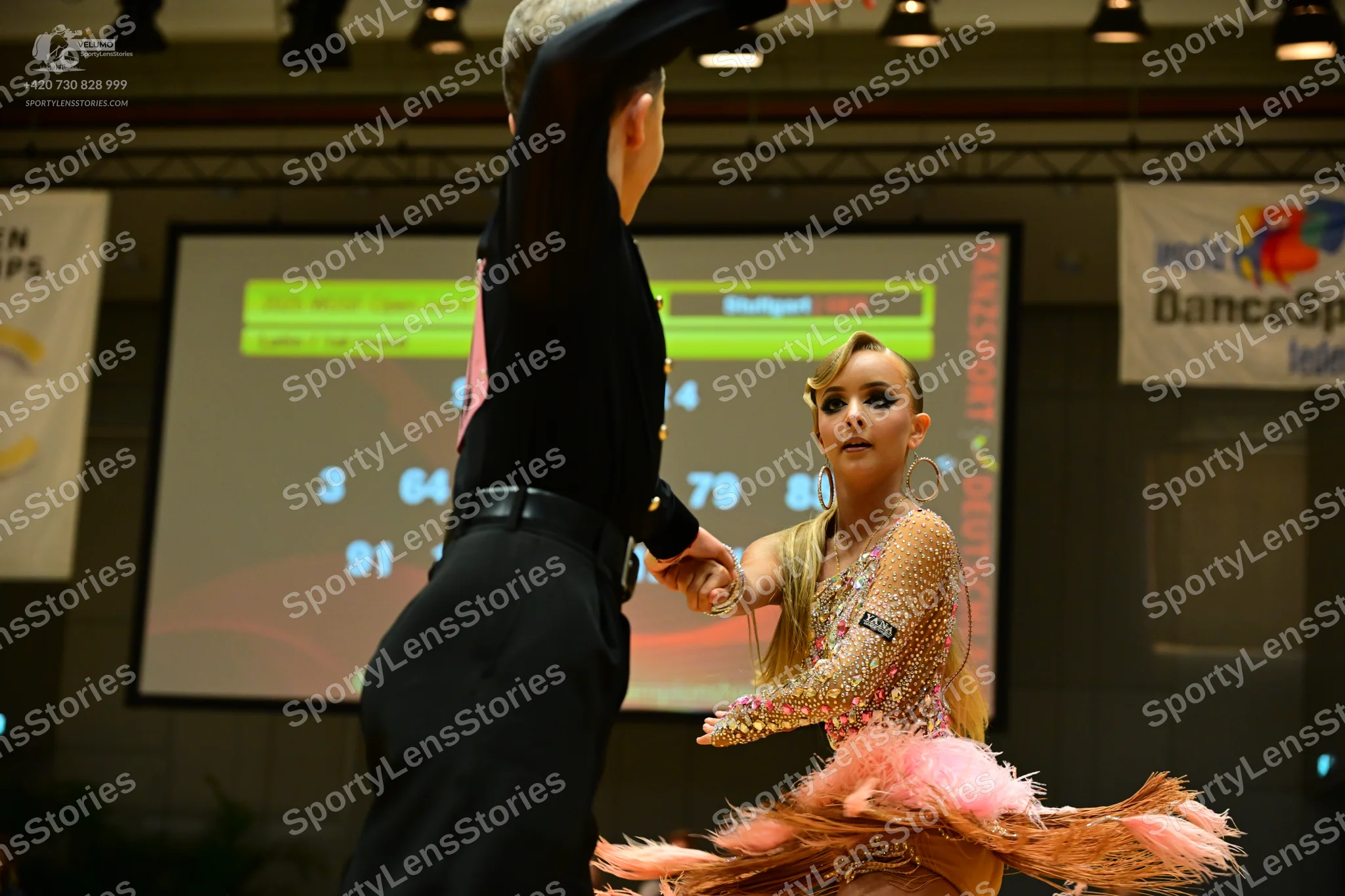 Dancesport competitor: Male dancer: black Latin dance top with pink accents and black trousers