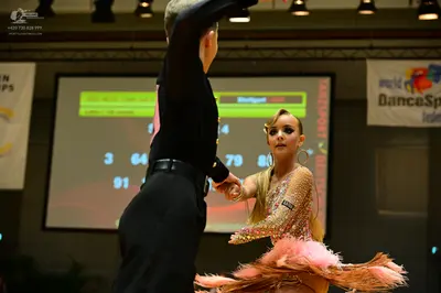 Dancesport competitor: Male dancer: black Latin dance top with pink accents and black trousers